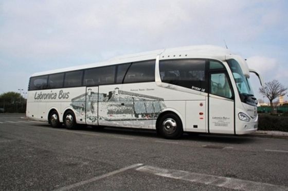 Vista lateral de un autobús blanco con el dibujo de un monumento