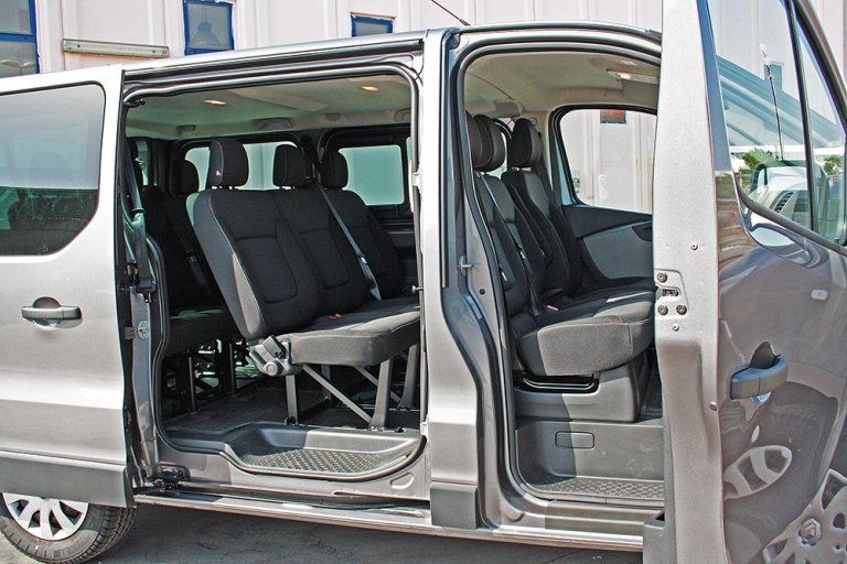Minivan con le porte aperte, possiamo vedere le sedili di colore grigio