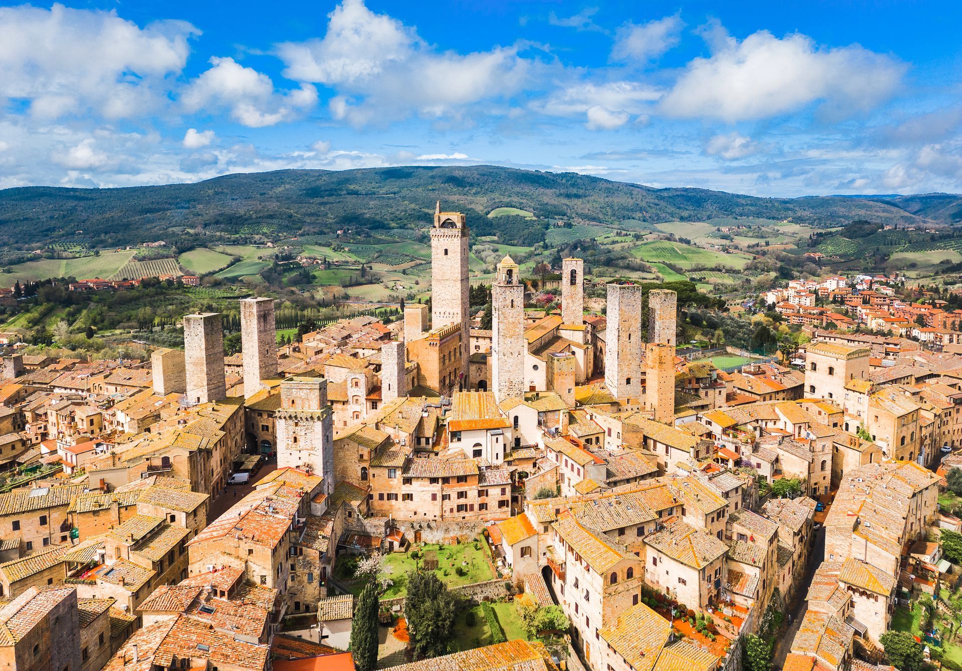 Veduta aerea della storica città di San Gimignano, in Italia, con le sue numerose torri medievali in pietra che si stagliano tra i tetti di terracotta.