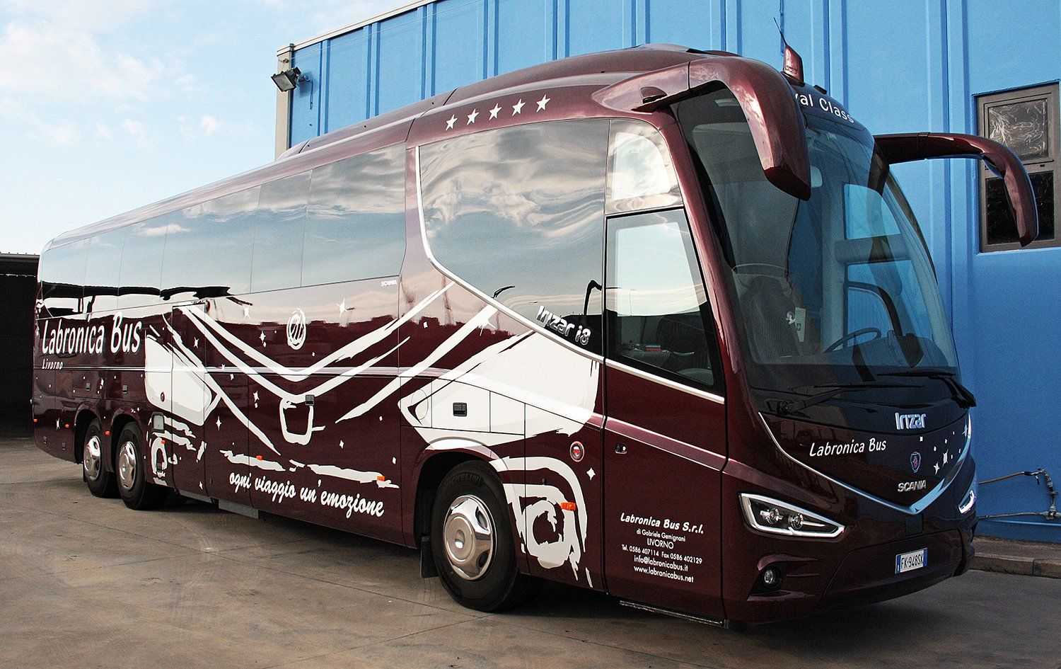 Vista laterale di un Pullman bianco con il disegno d’un monumento