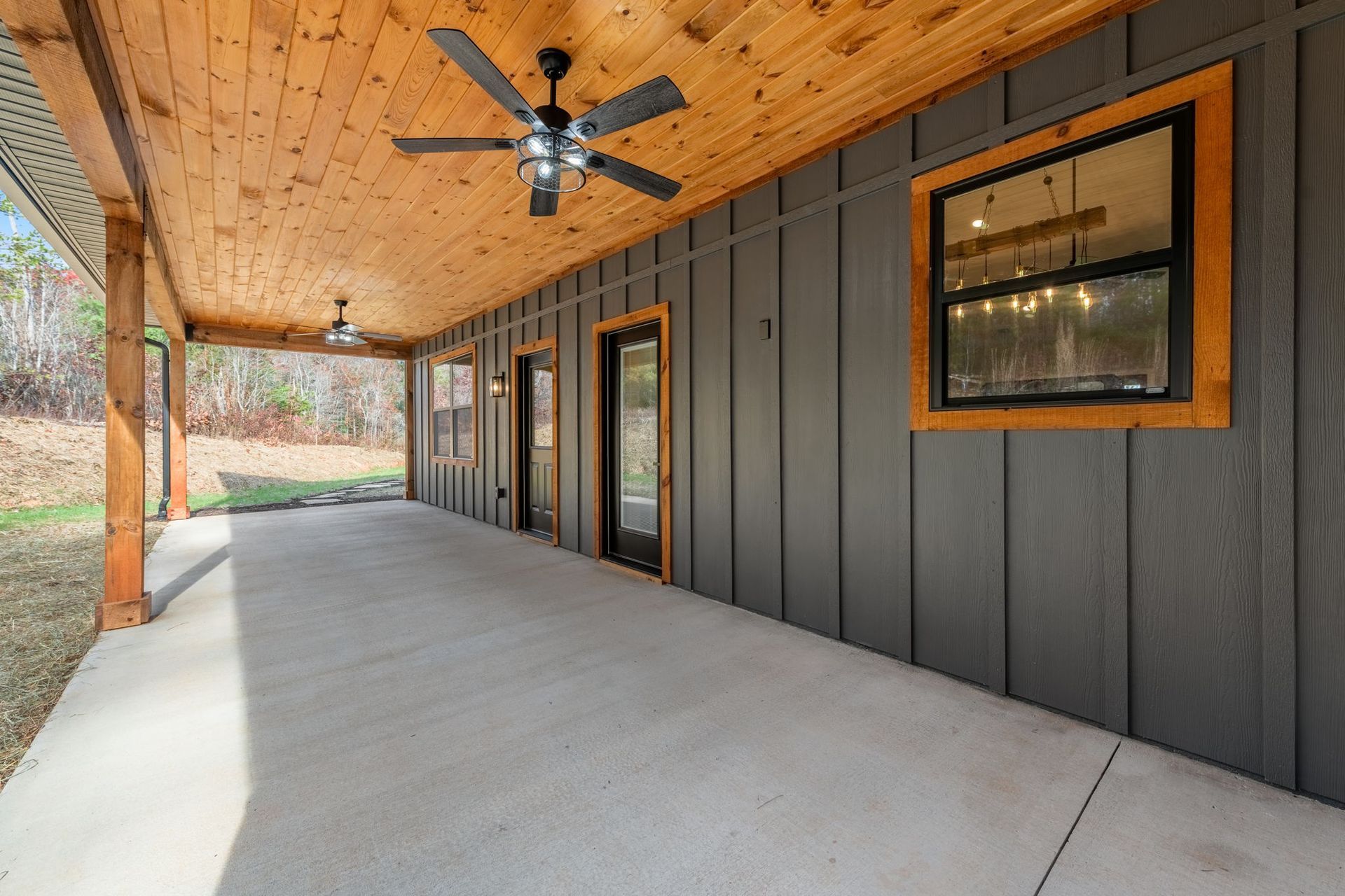 There is a ceiling fan on the porch of a house.