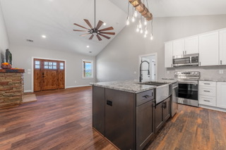 A kitchen with a large island and a ceiling fan.