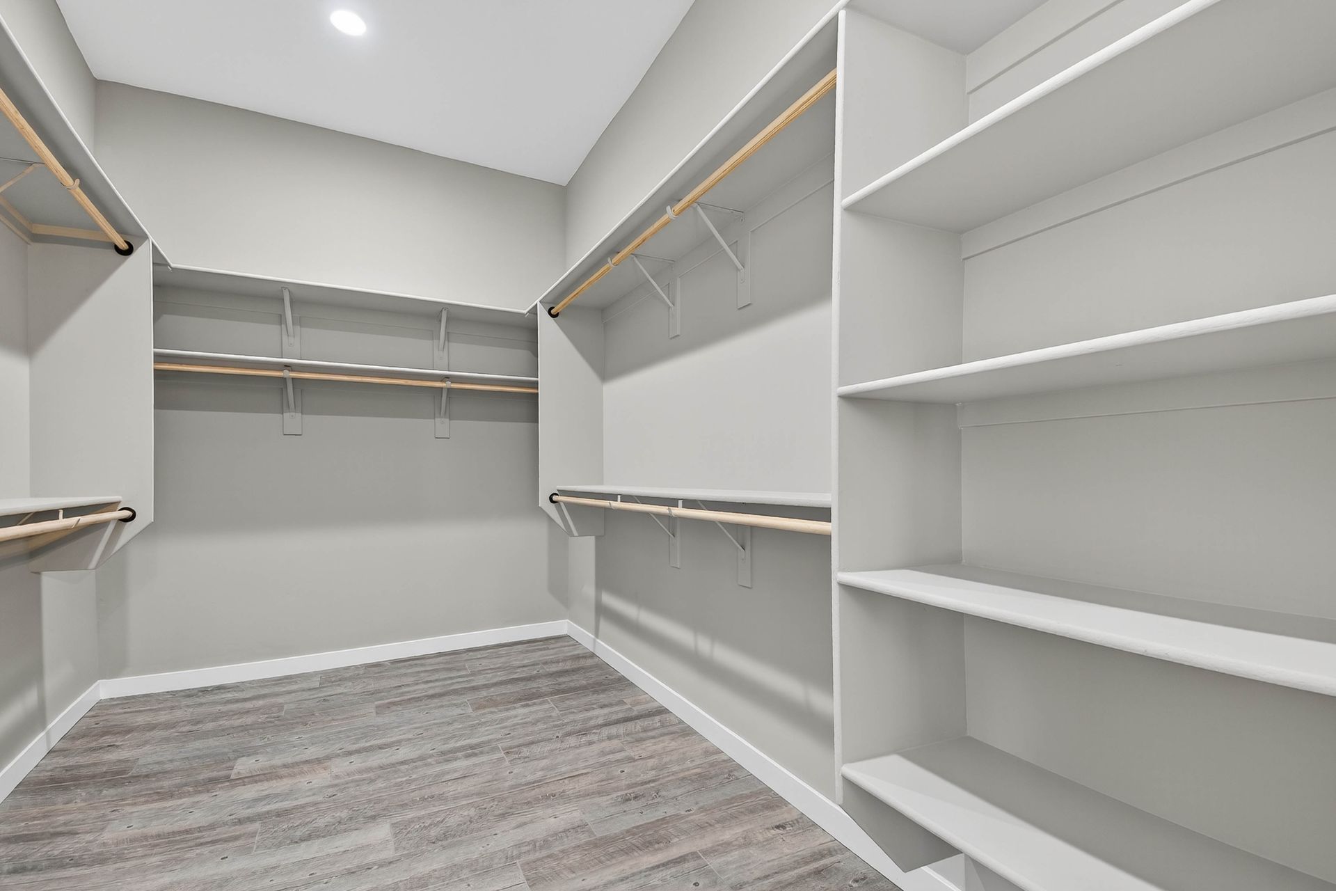 Empty room with white paneled wall, wood ceiling, and covered floor in a renovation space
