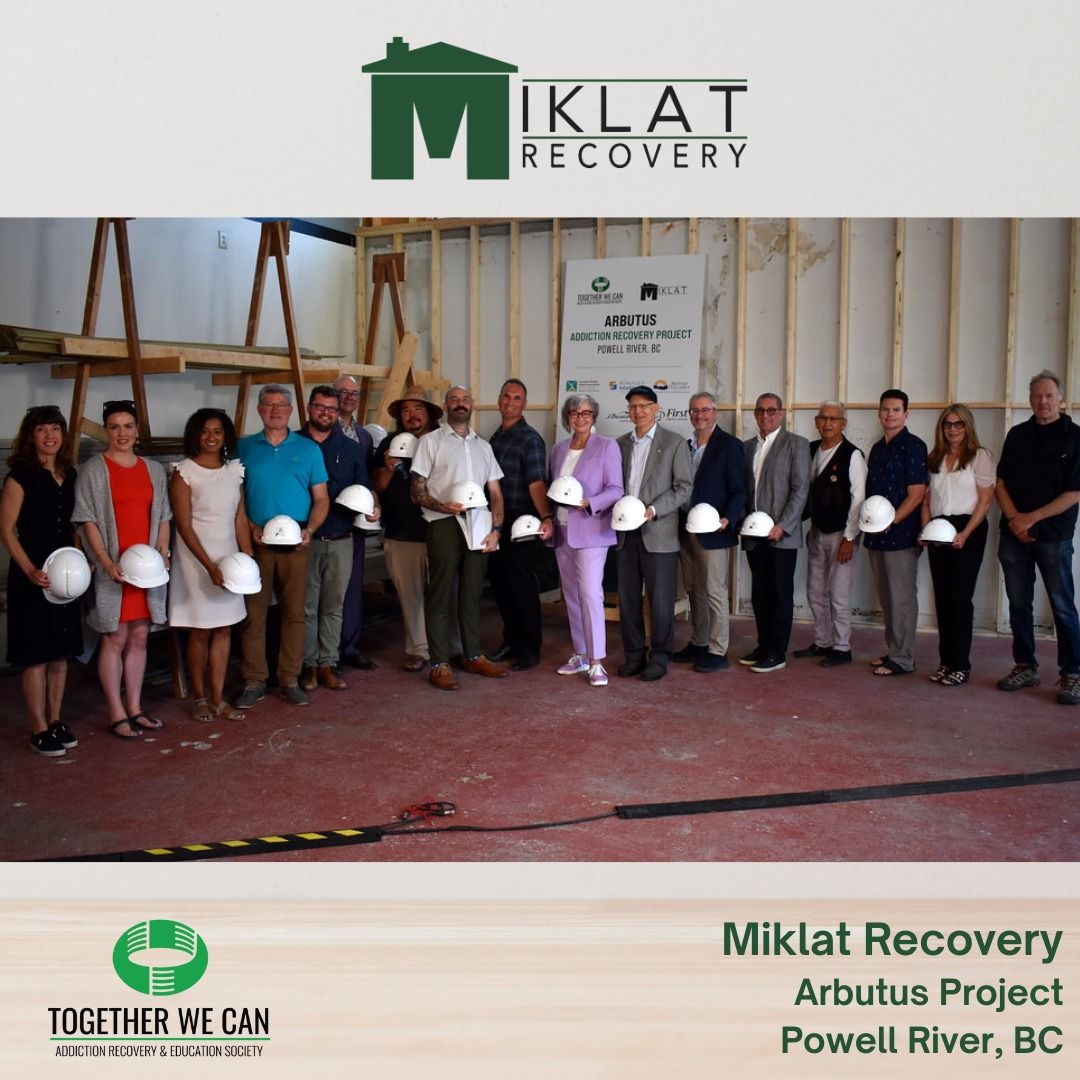 Group photo at the Miklat Recovery Arbutus Project site in Powell River, BC. People in suits and hard hats stand in a building.
