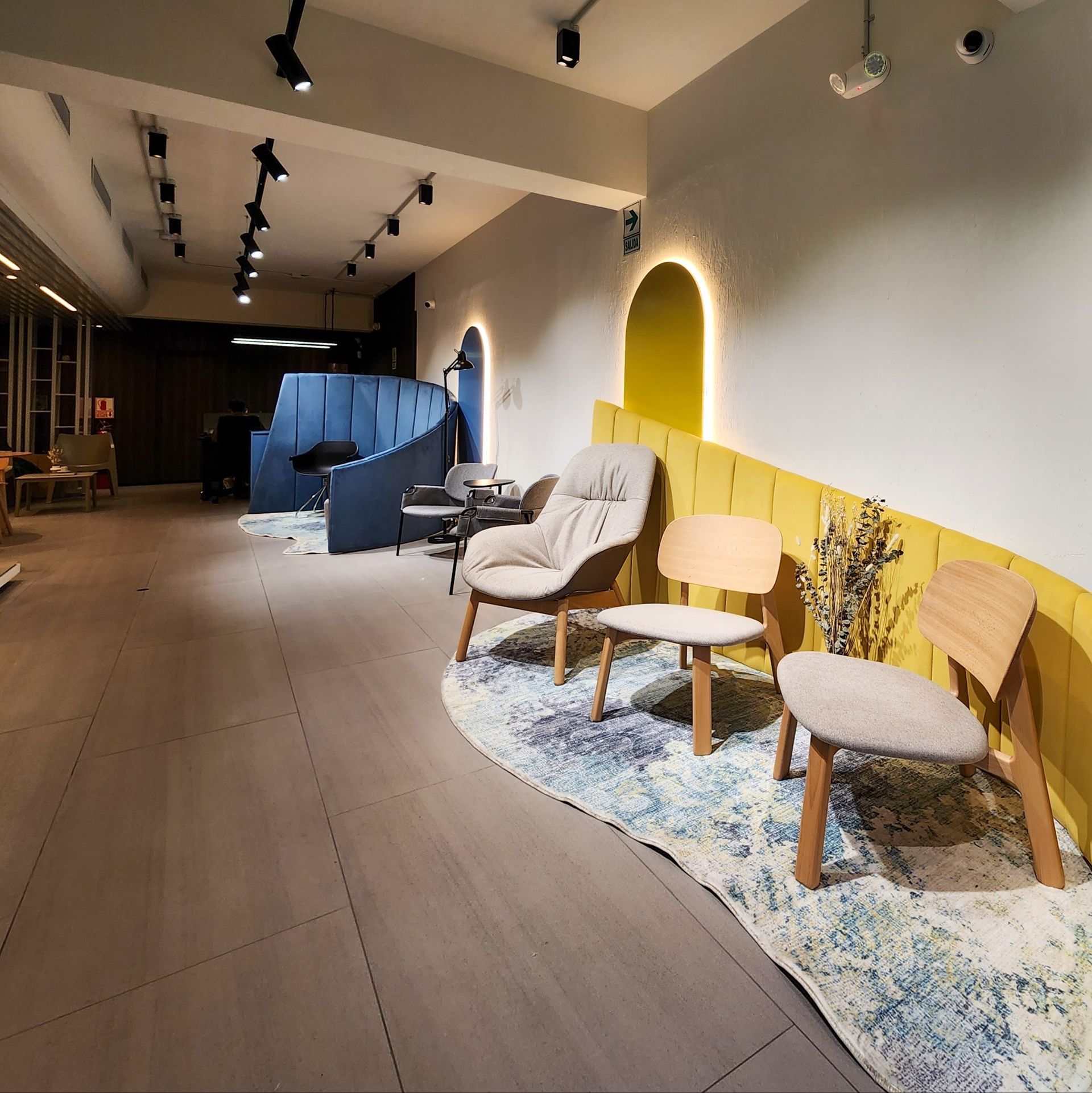 Una habitación con sillas y una alfombra en el suelo.