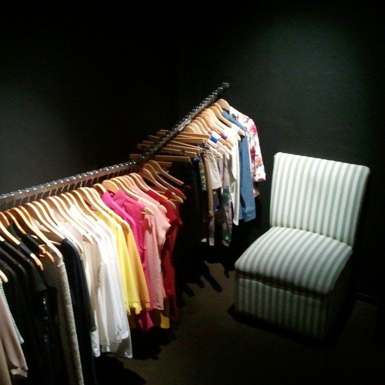 Un armario lleno de ropa y una silla.