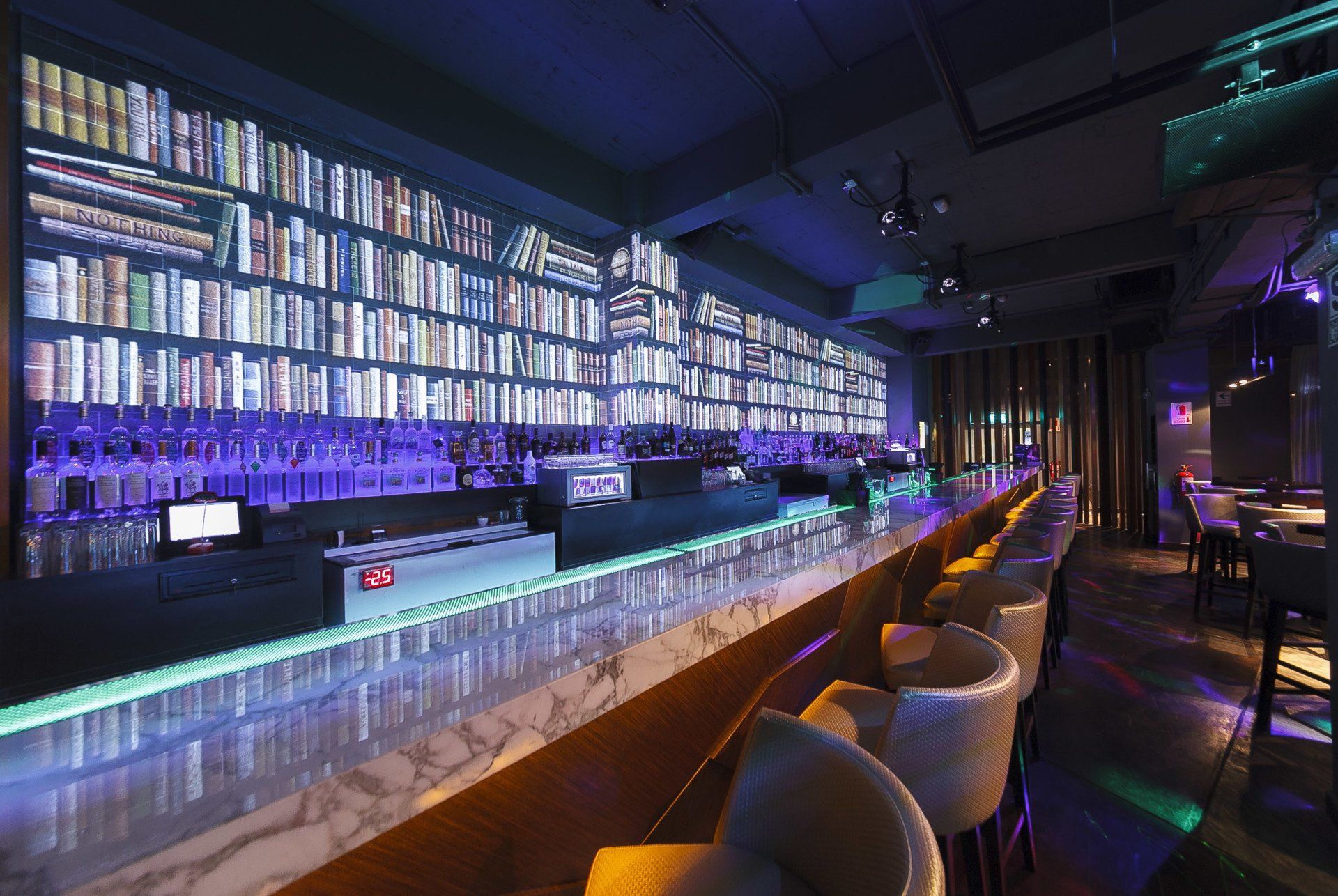 Una barra larga en un restaurante con muchas botellas encima.