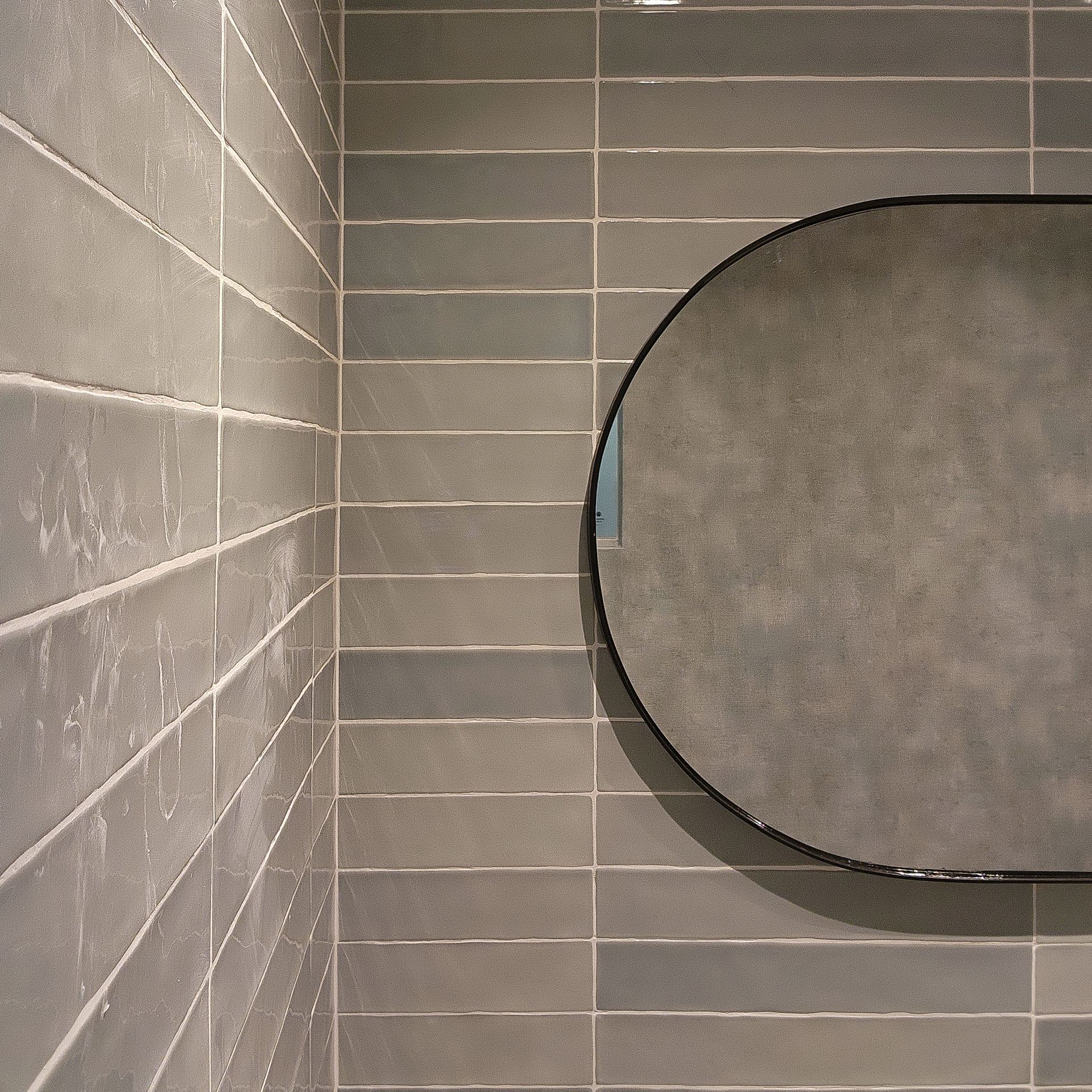 Un baño con un espejo redondo en la pared.