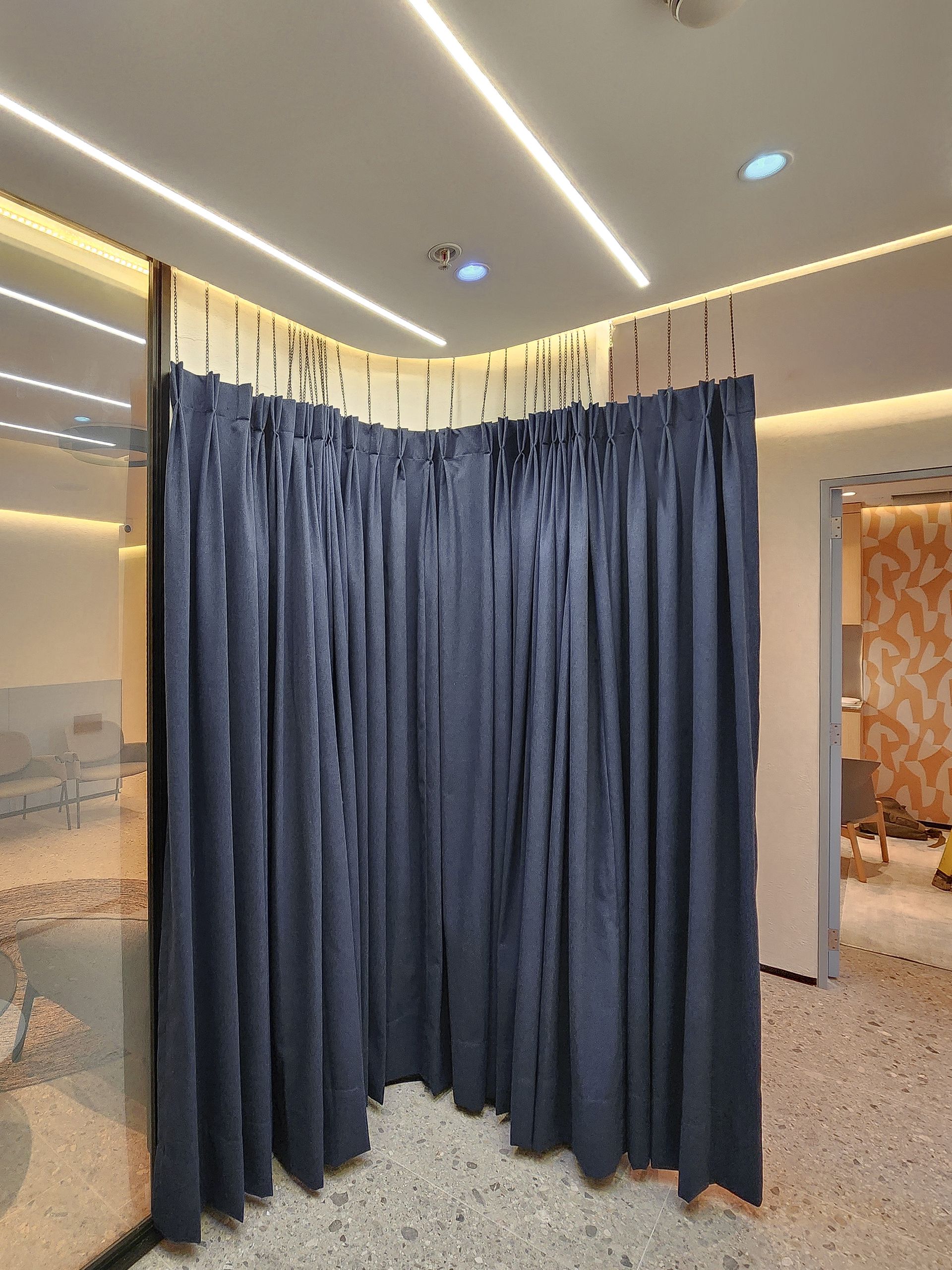 Una habitación con una cortina azul entre dos habitaciones.