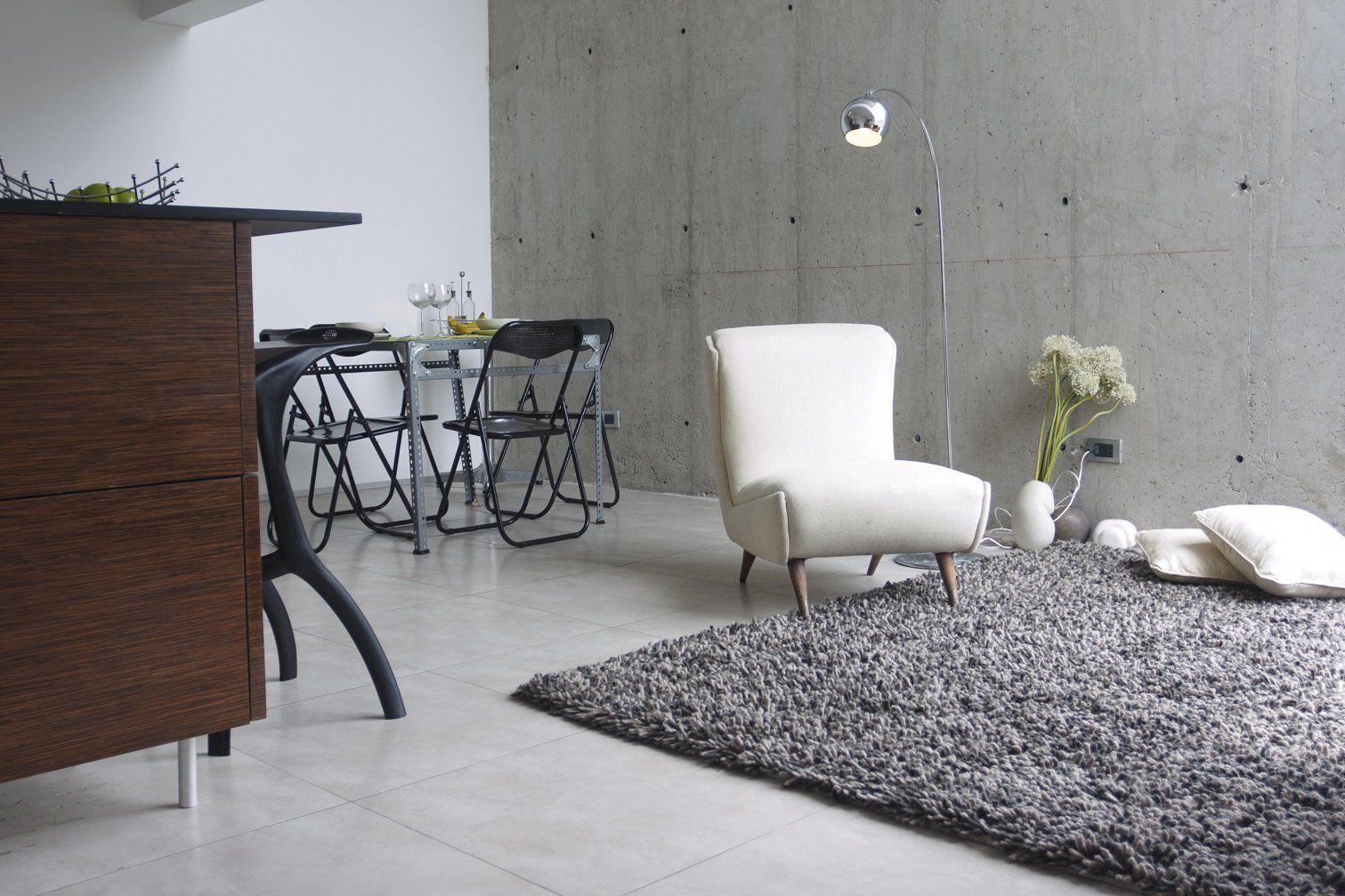 Una sala de estar con una silla blanca y una alfombra.