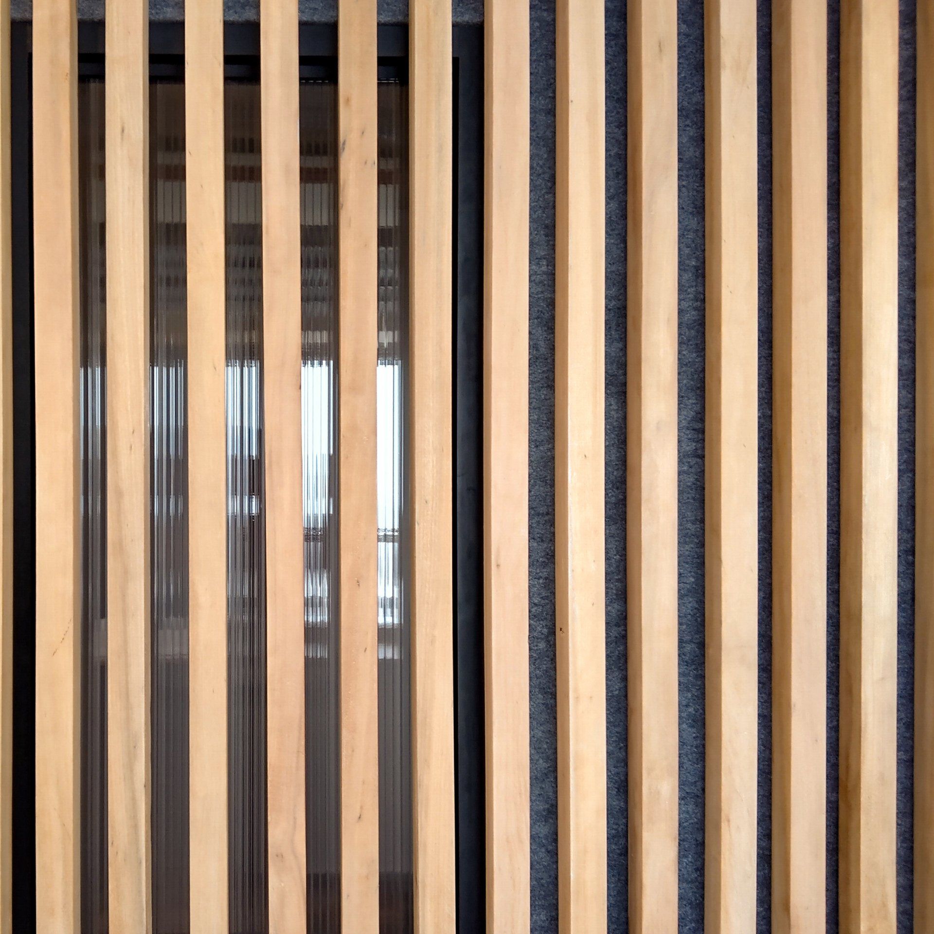 Un primer plano de una valla de madera con una ventana al fondo.