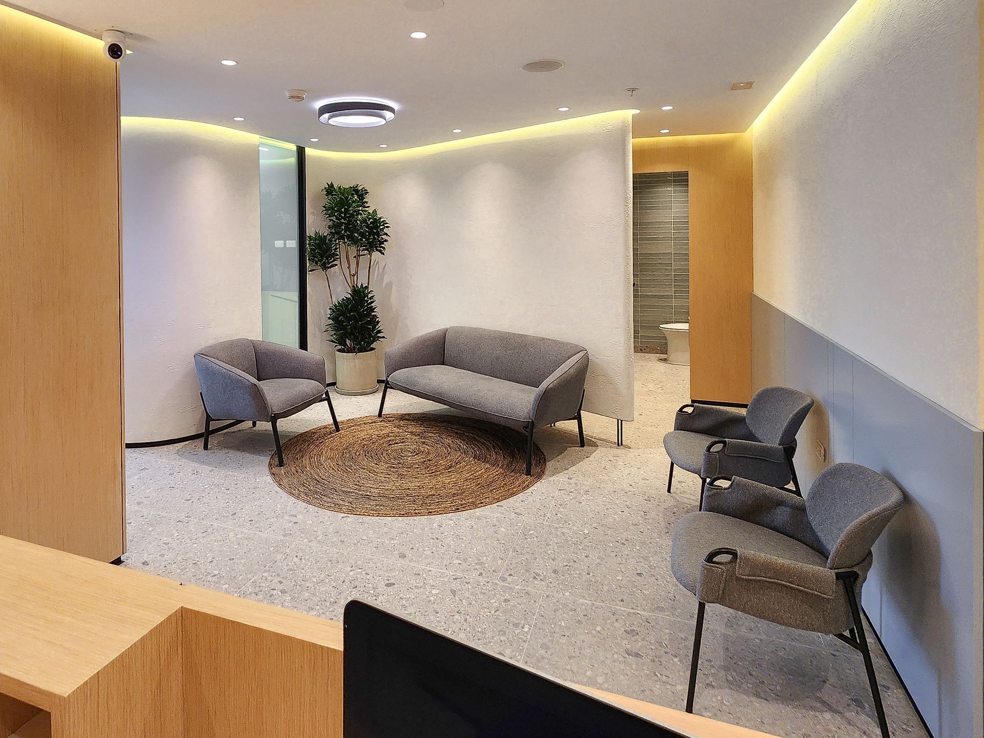 Una sala de espera con un sofá, sillas y una alfombra.