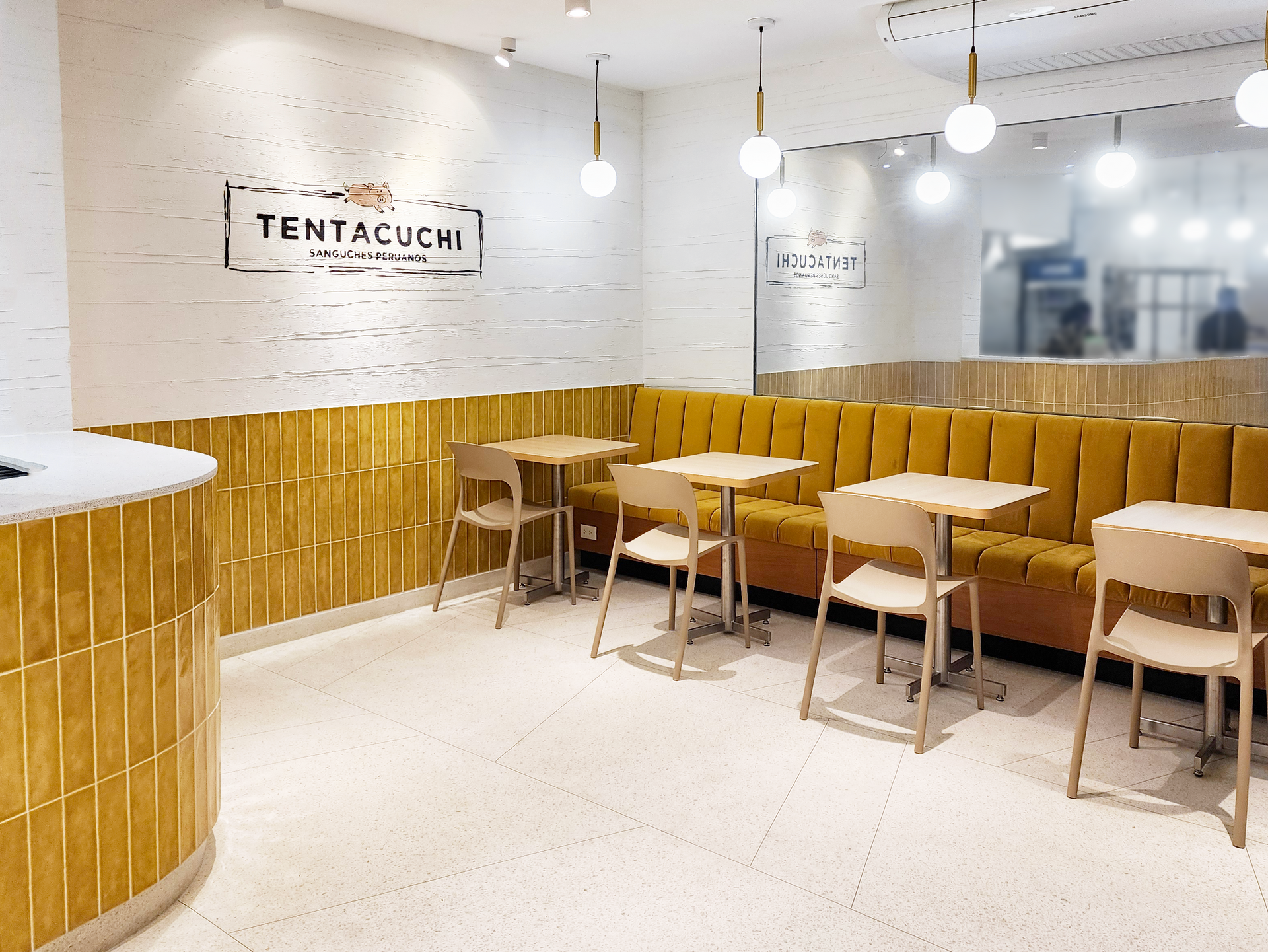 Un restaurante con mesas y sillas y un sofá amarillo.