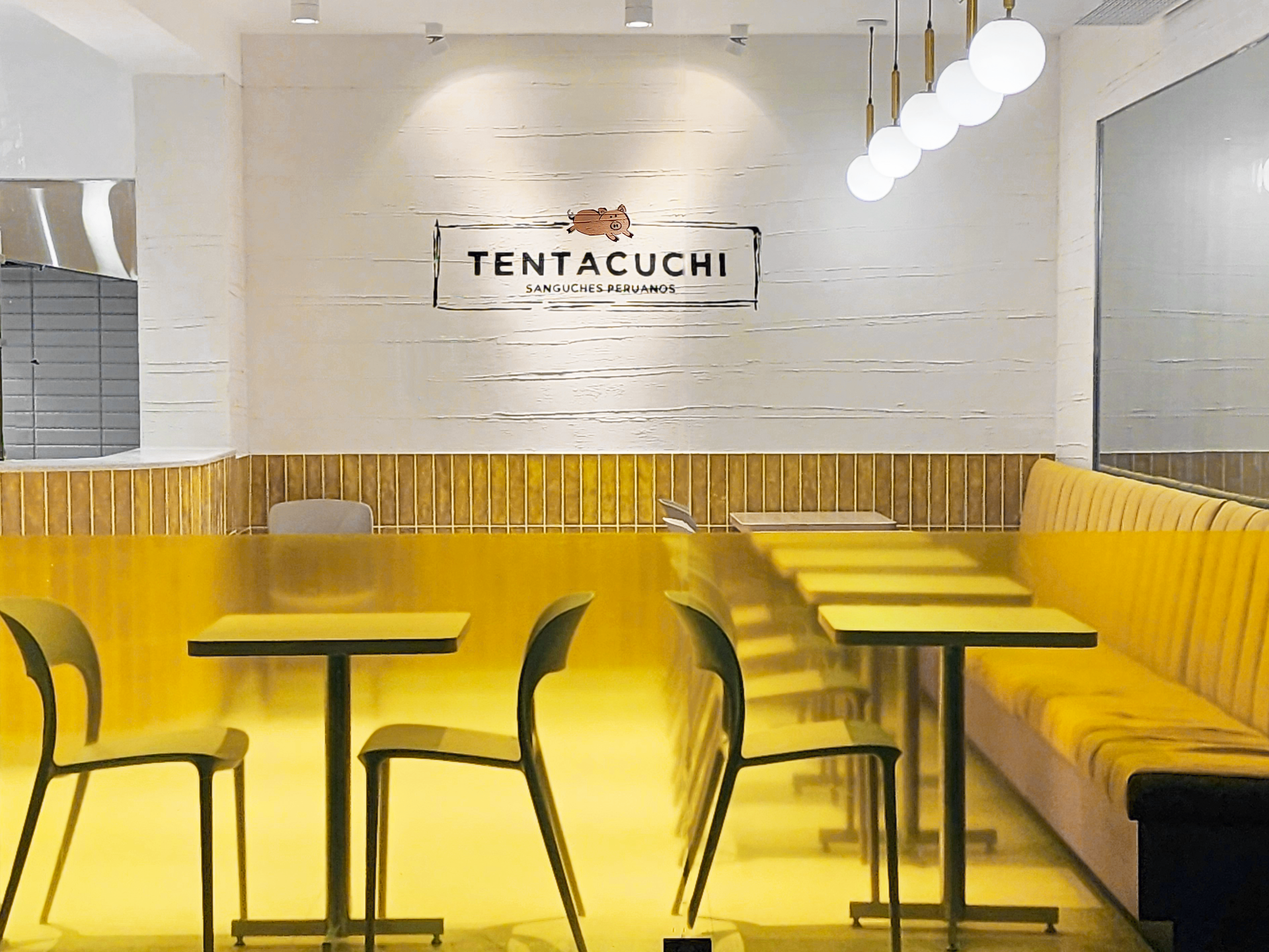 Un restaurante con mesas y sillas y un cartel que dice tentacuchi