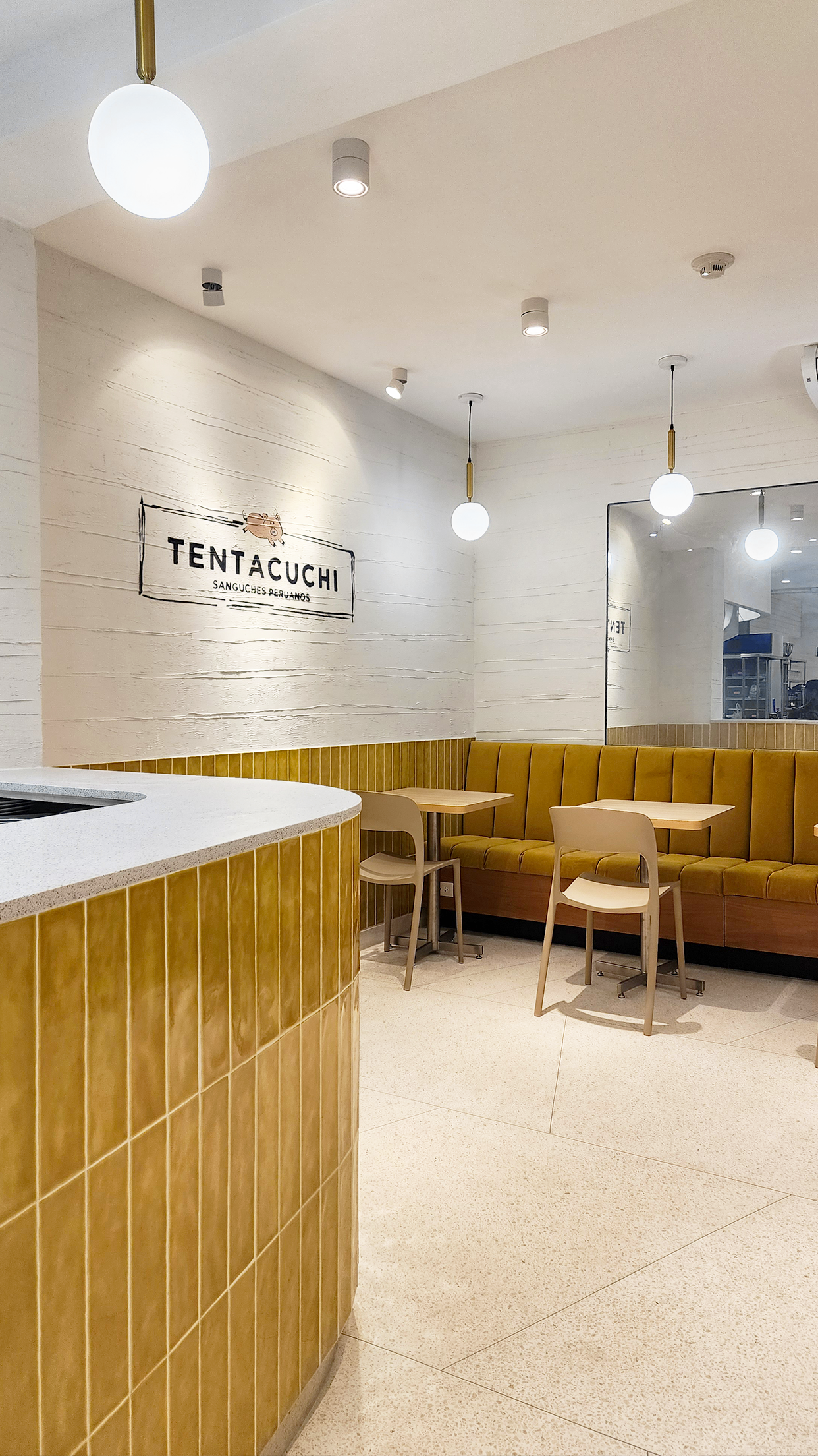 Un restaurante con mesas y sillas y un sofá amarillo.