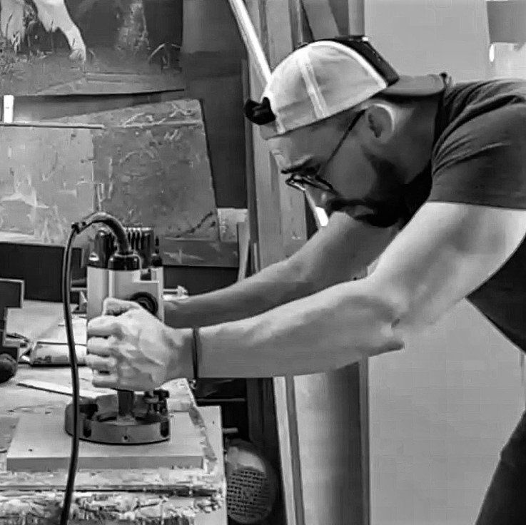 Un hombre está trabajando en una máquina en una foto en blanco y negro.