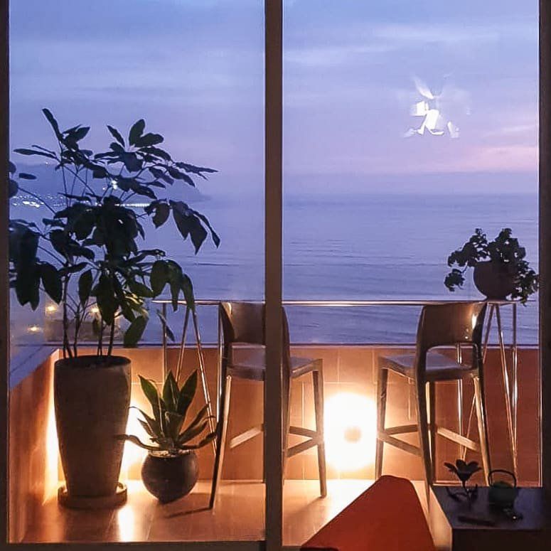 Un balcón con vista al mar por la noche.