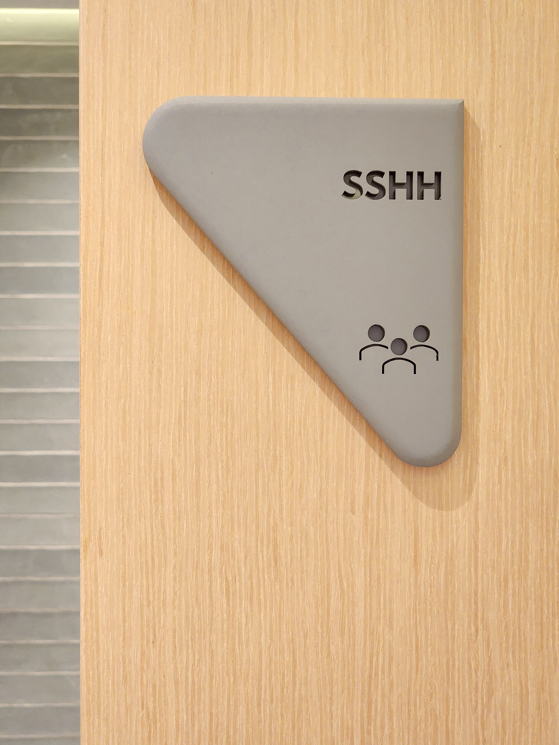 Un cartel en una pared de madera que dice sshh.