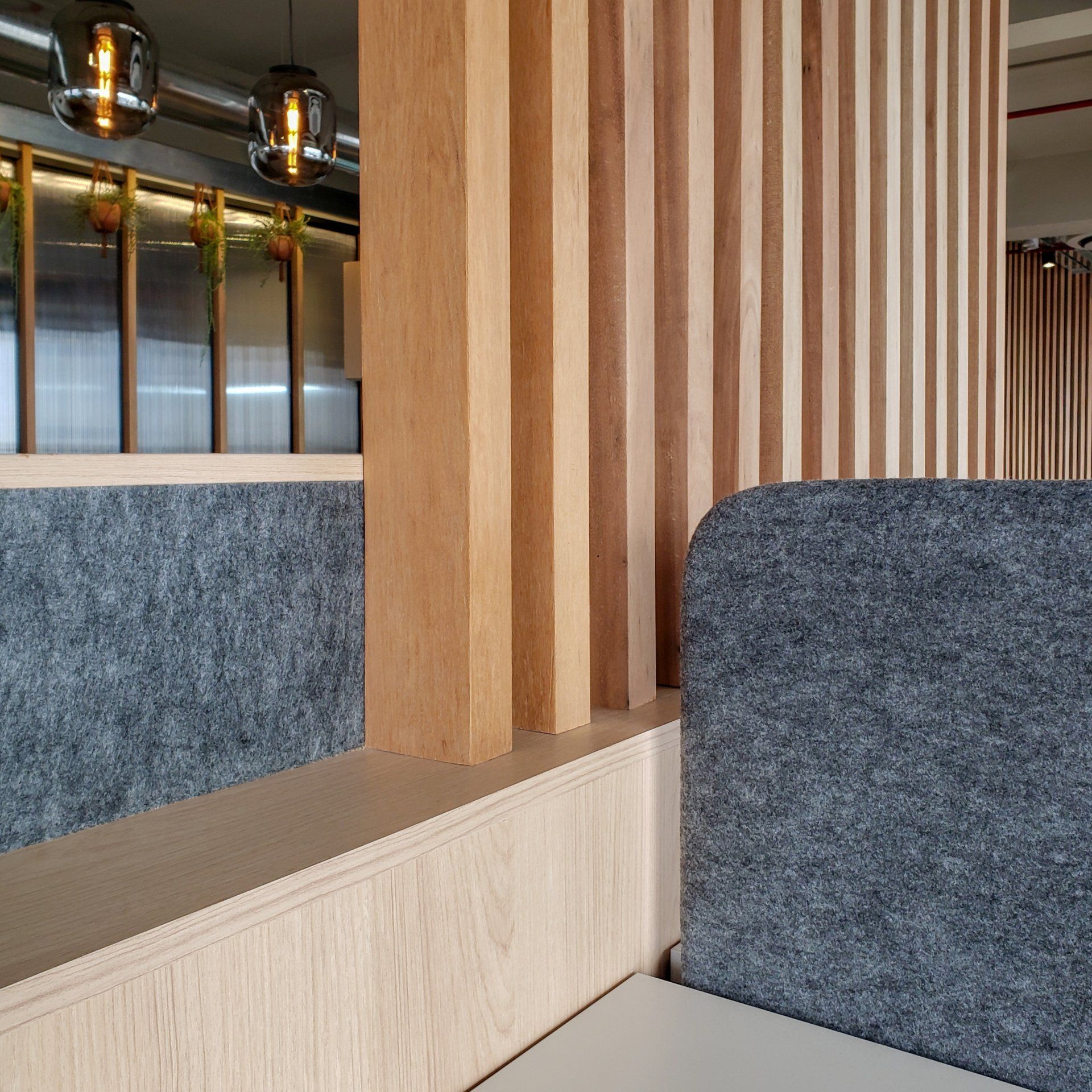 Una habitación con una pared de madera y un sofá gris.