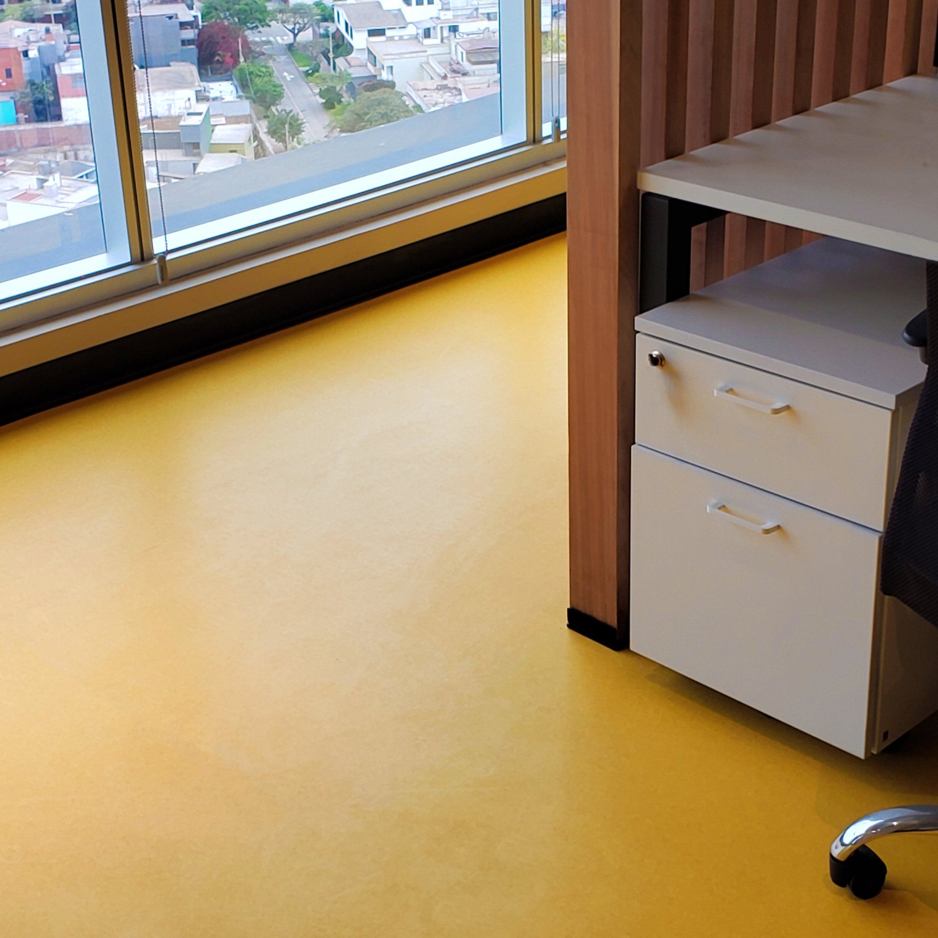 Un piso amarillo en una habitación con ventana.