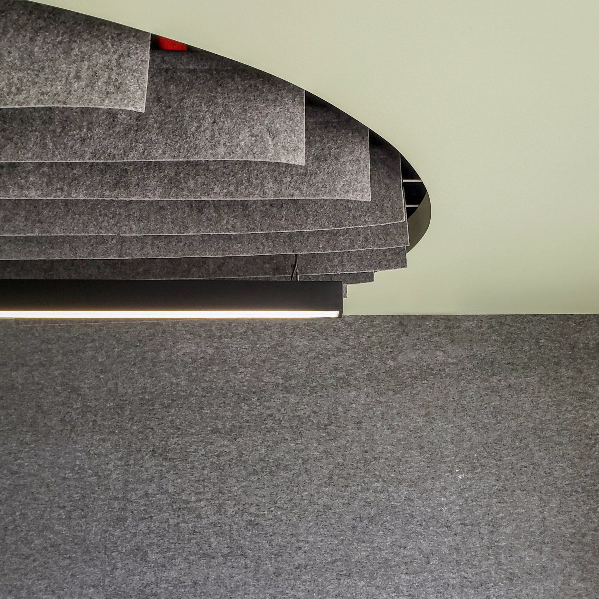 Un suelo de moqueta gris con una escalera al fondo.