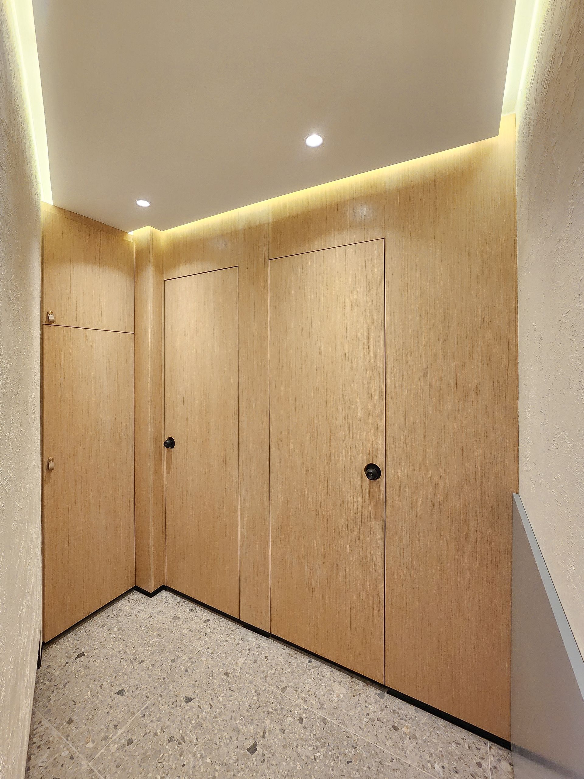 Un pasillo con puertas de madera y una luz de techo.