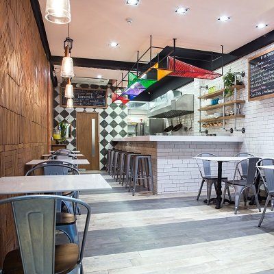 Un restaurante con mesas y sillas y una pizarra en la pared.