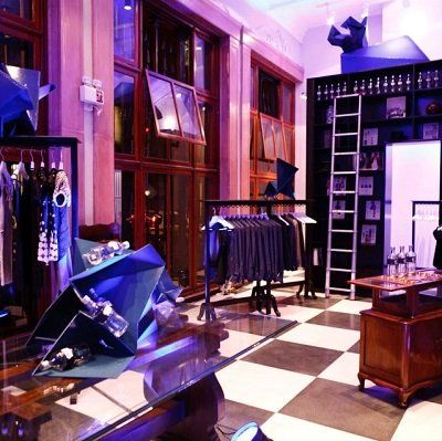 Una tienda con ropa colgada en perchas y un suelo a cuadros.