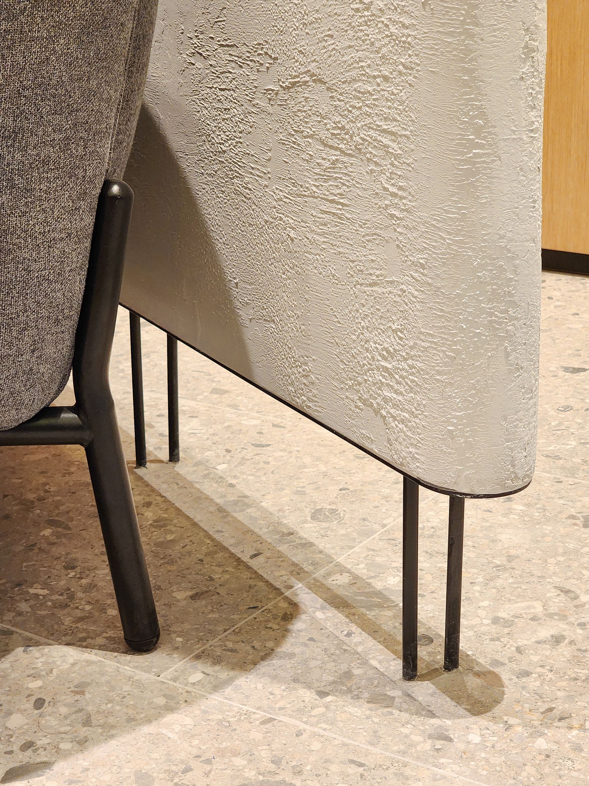 Una silla está colocada sobre un suelo de baldosas al lado de una mesa.