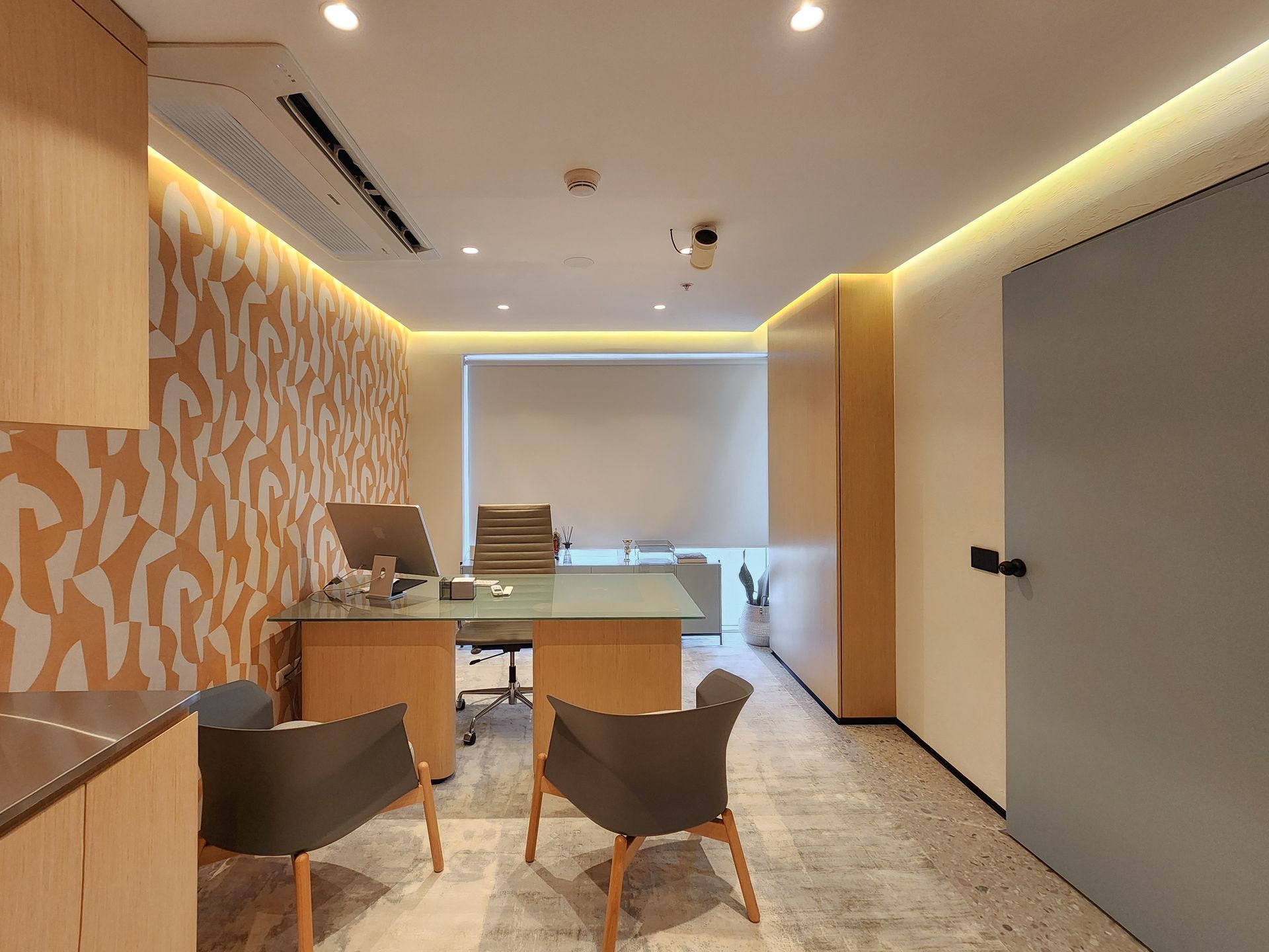 Una habitación con un escritorio y sillas.