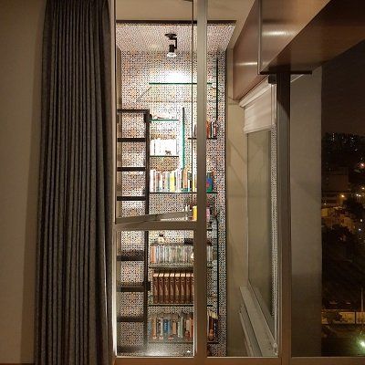 Una habitación con una escalera que conduce a una estantería.