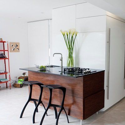 Una cocina con una isla de madera y dos taburetes.