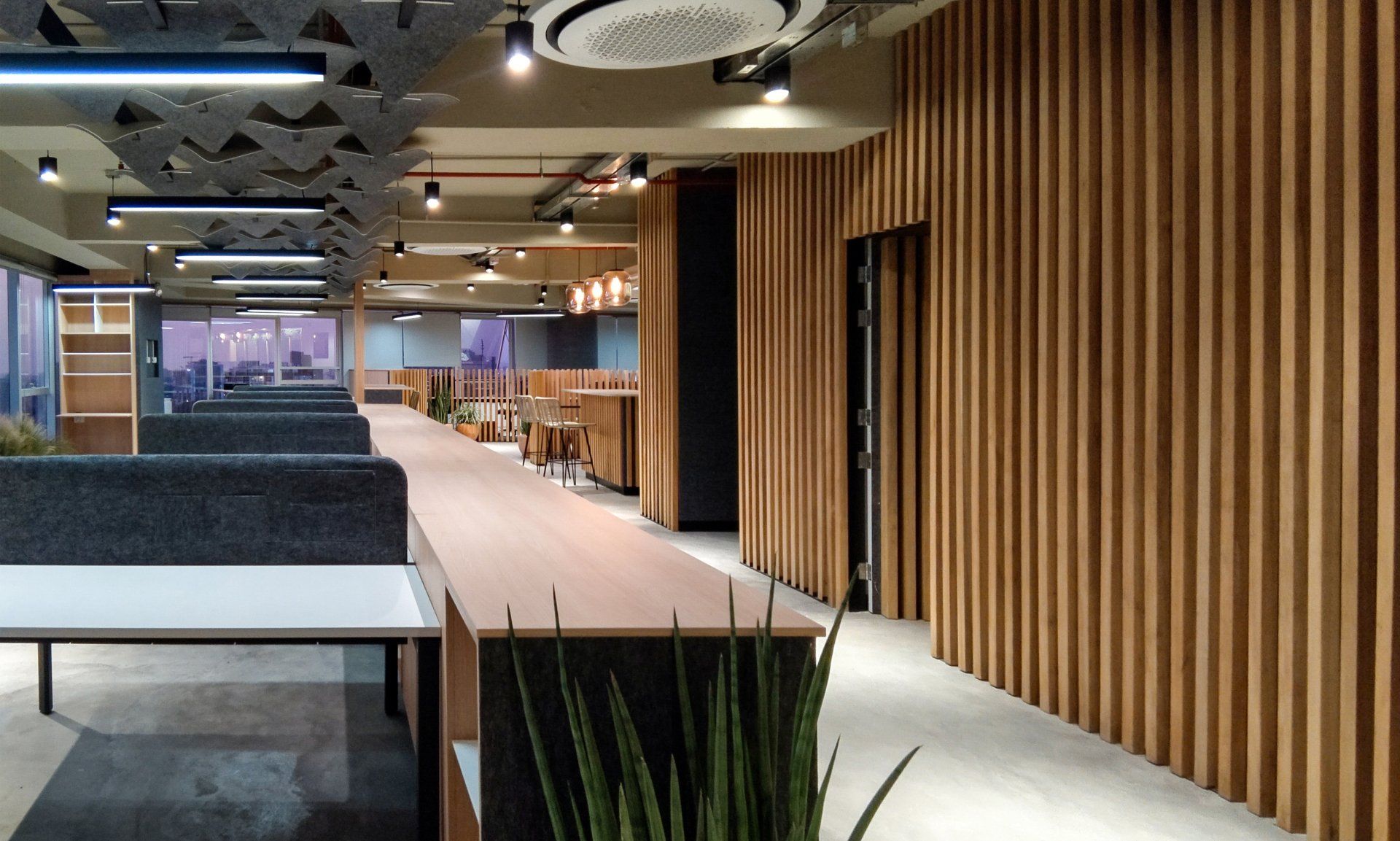 Una habitación grande con una pared de madera y una mesa larga.