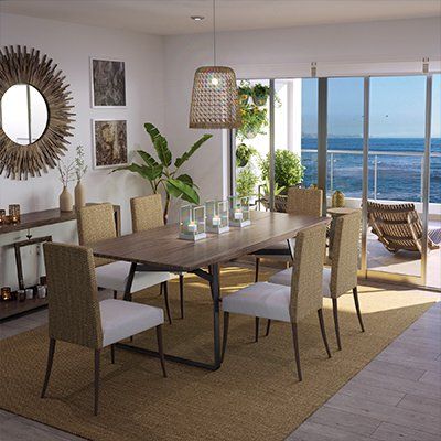 Un comedor con mesa y sillas y vista al mar.
