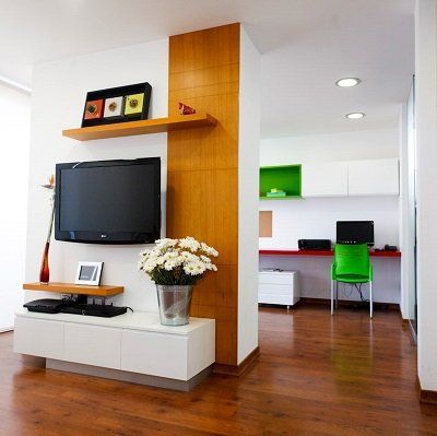 Una sala de estar con un televisor de pantalla plana en la pared.