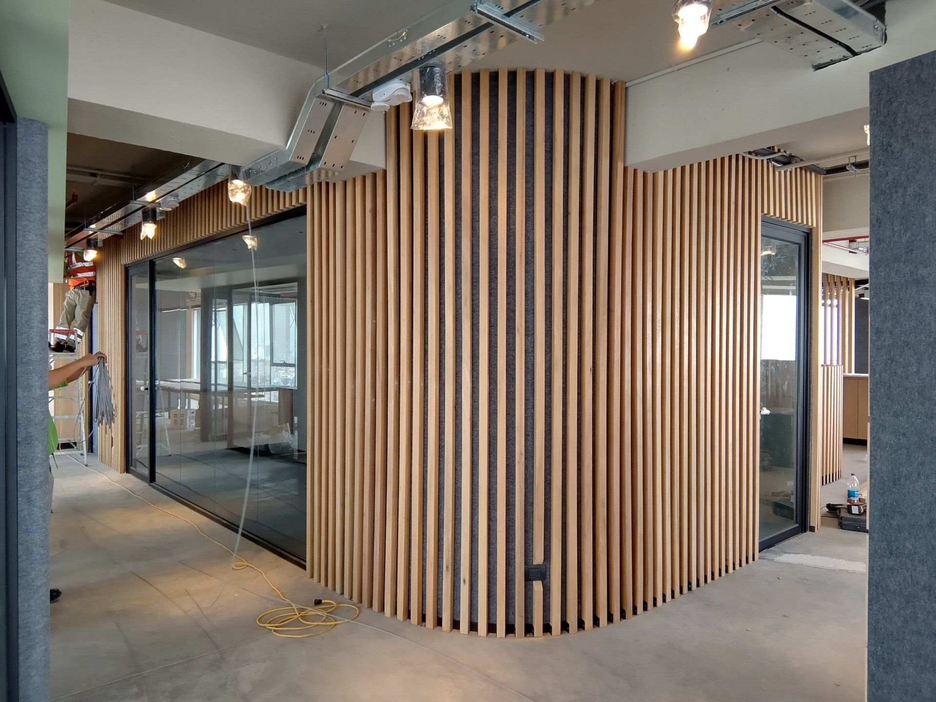 Una habitación con una pared de madera y puertas de cristal.