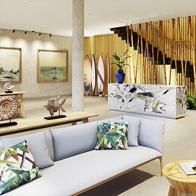 Una sala de estar con un sofá y escaleras al fondo.