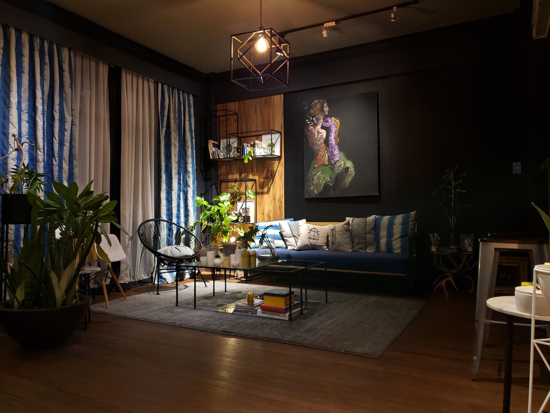 Una sala de estar con un sofá, una mesa, sillas y un cuadro en la pared.