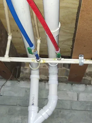 White pipes with red and blue hose attached to them