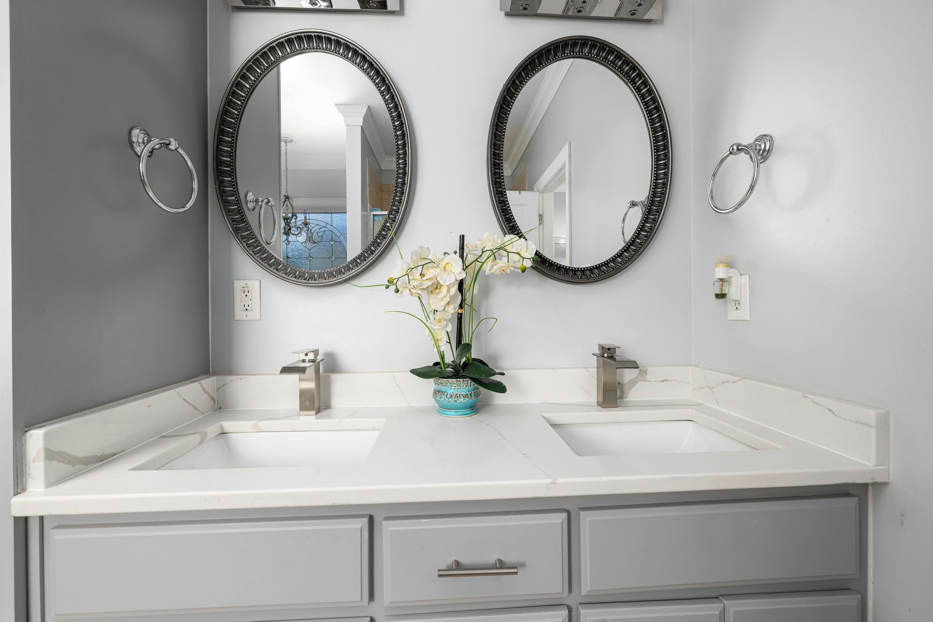 A bathroom with two sinks and two mirrors on the wall.