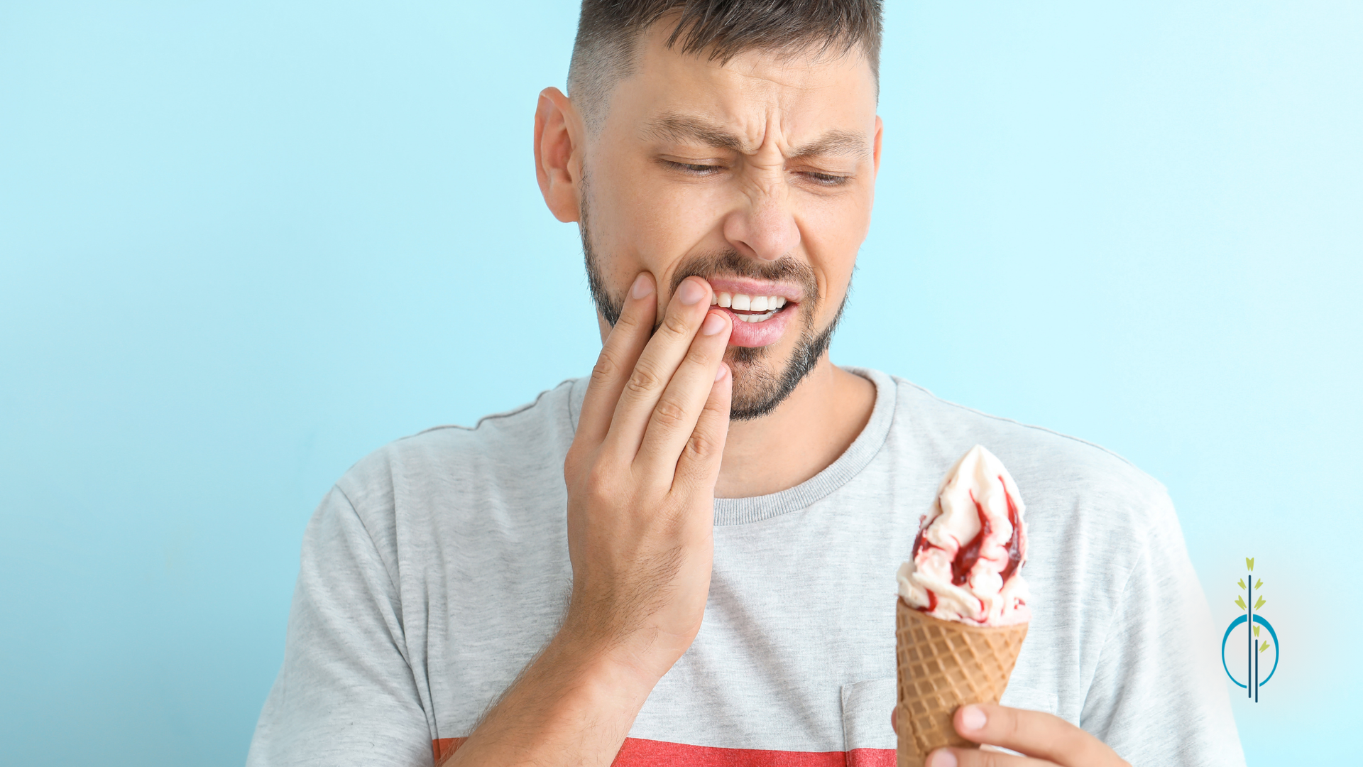 A man is holding an ice cream cone and having a toothache.