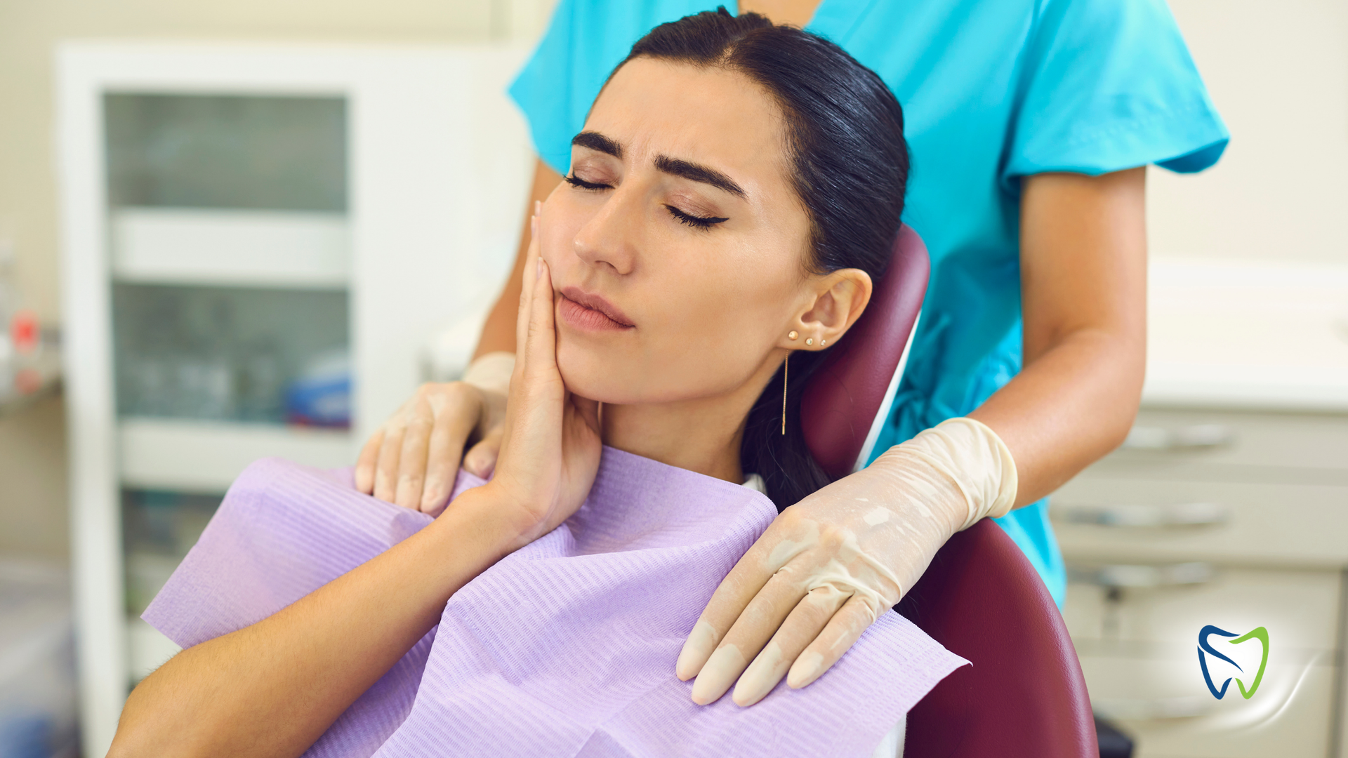 Woman holding face in pain, eyes closed, white tank top, light background.