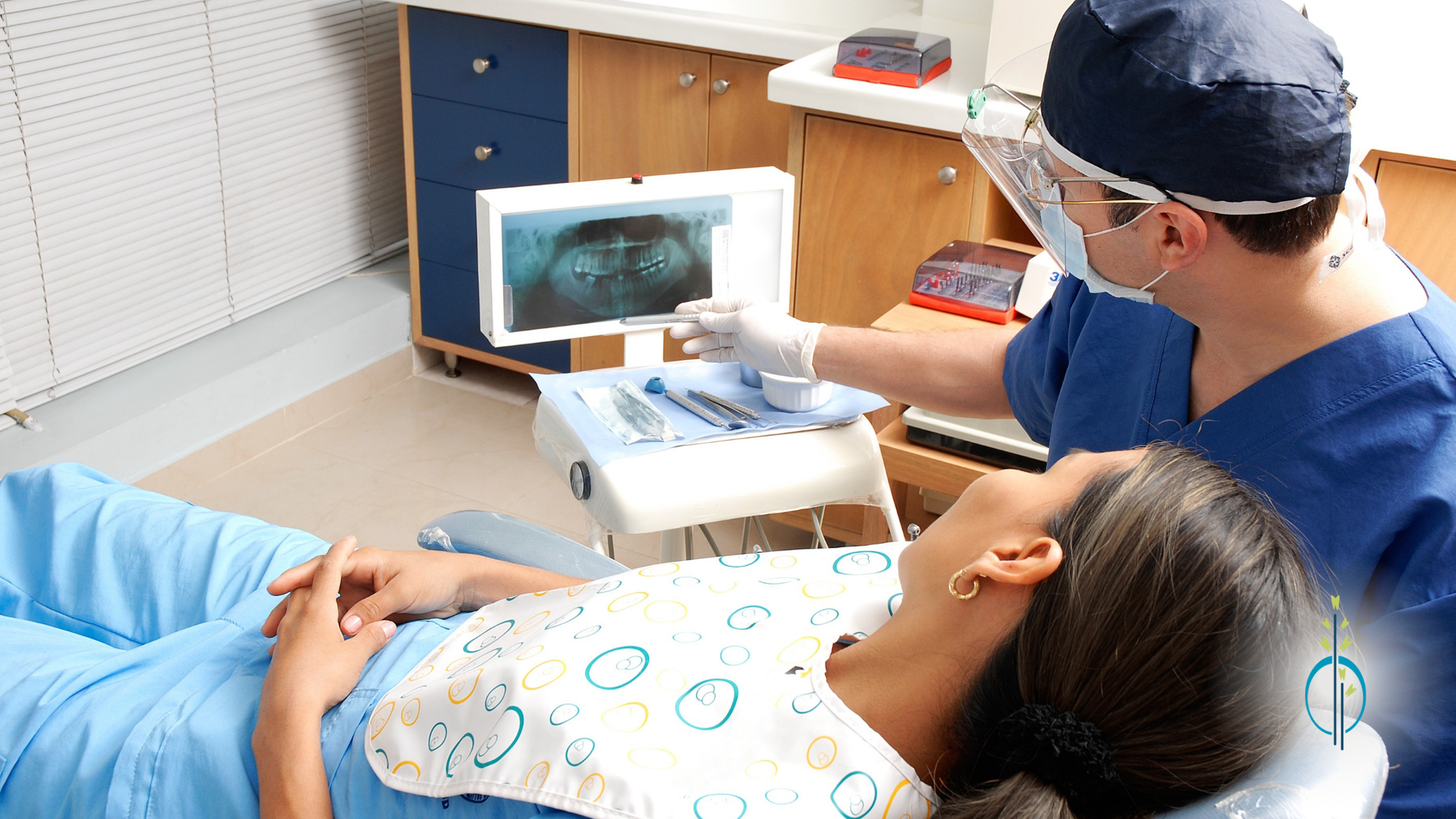 A dentist is examining a patient 's teeth in a dental office.