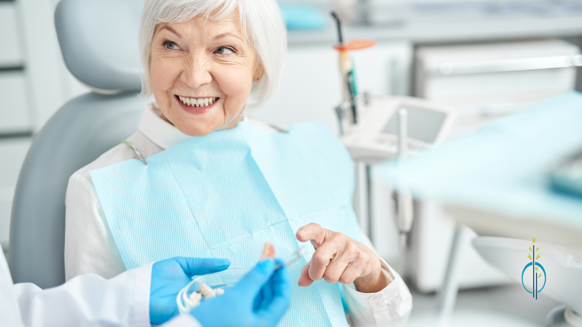 An elderly woman is smiling while sitting in a dental chair.