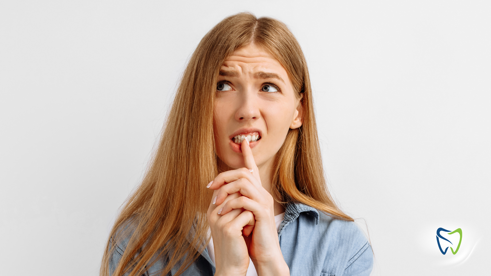A woman is holding her finger to her mouth.