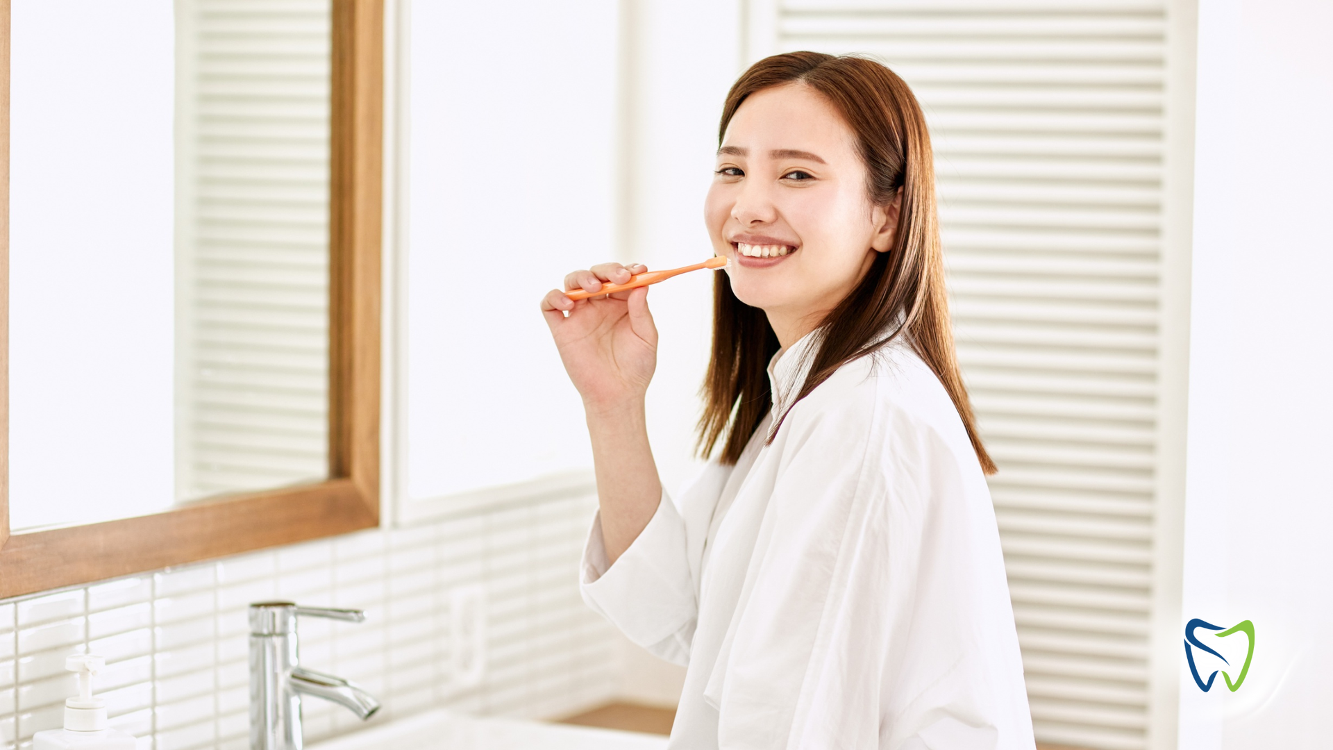 Woman brushing teeth with a green toothbrush, mouth open, white foam visible.