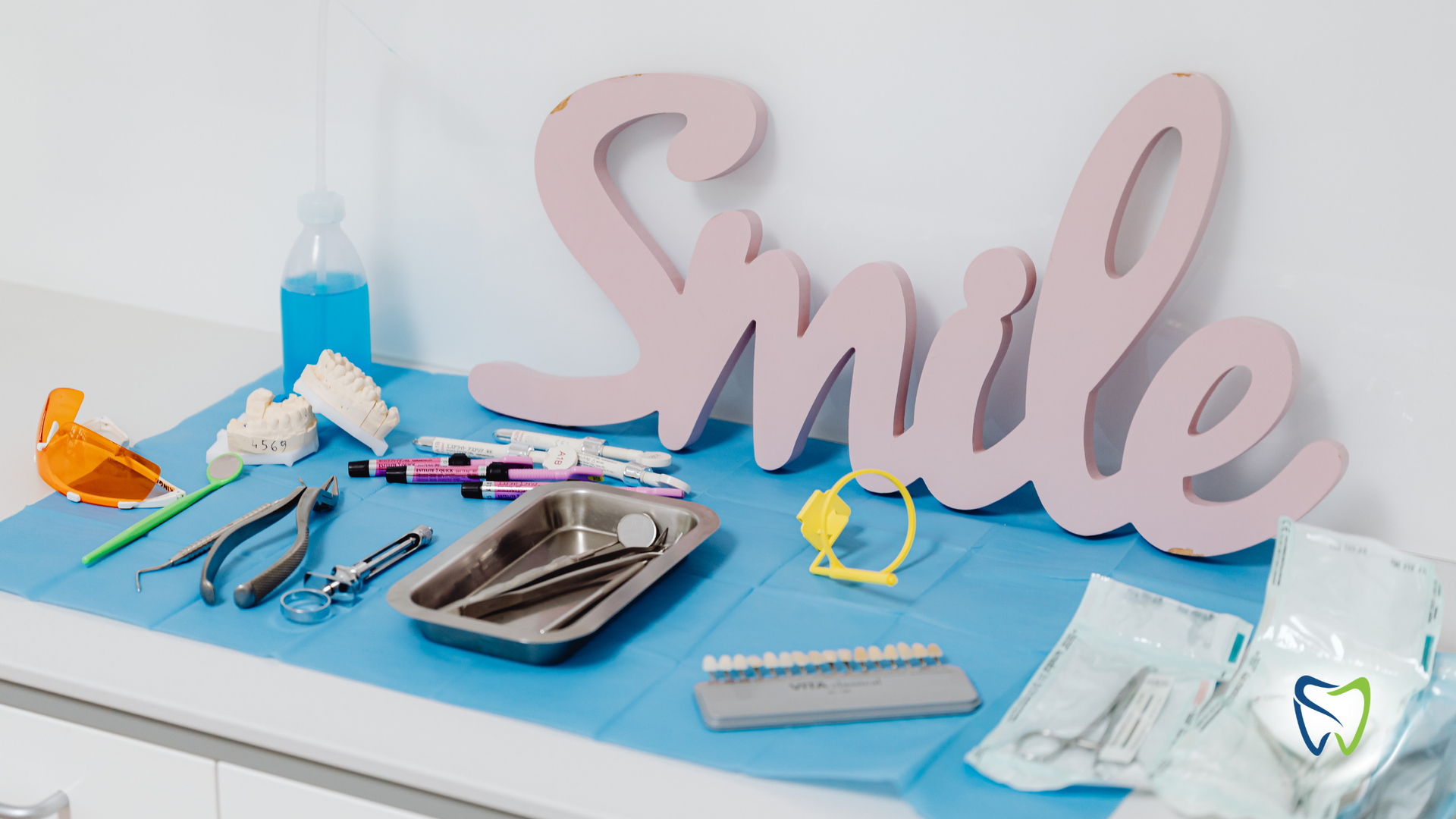 A table with dental instruments and a sign that says smile.