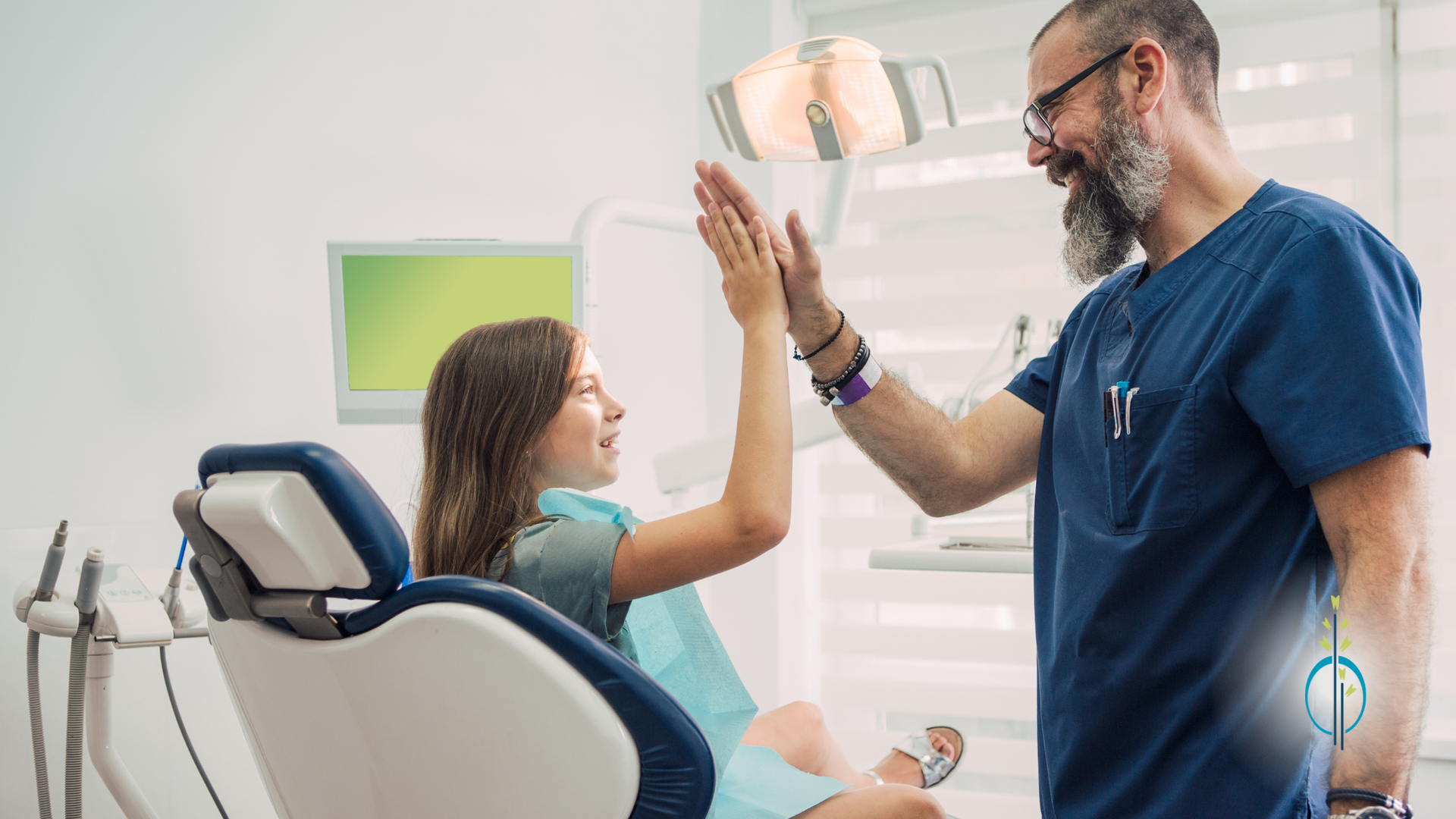 A dentist is giving a high five to a young girl in a dental chair.