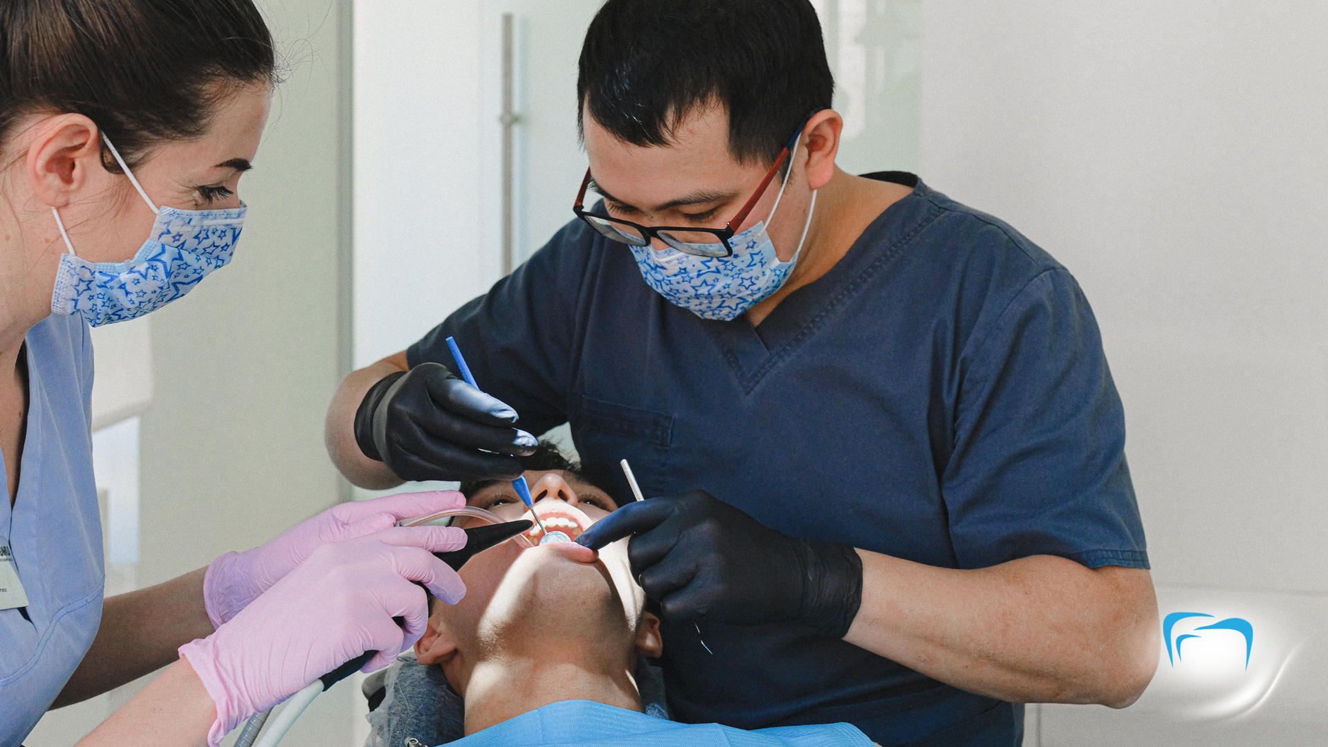 A dentist is examining a patient 's teeth in a dental office.