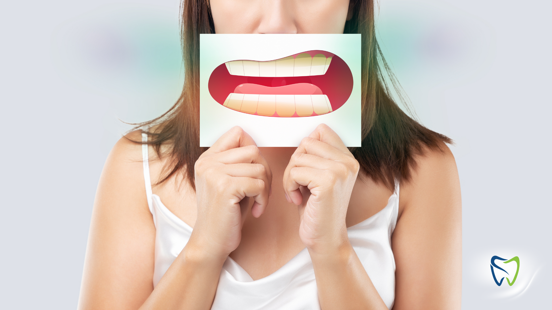 A woman is holding a picture of her mouth in front of her face.